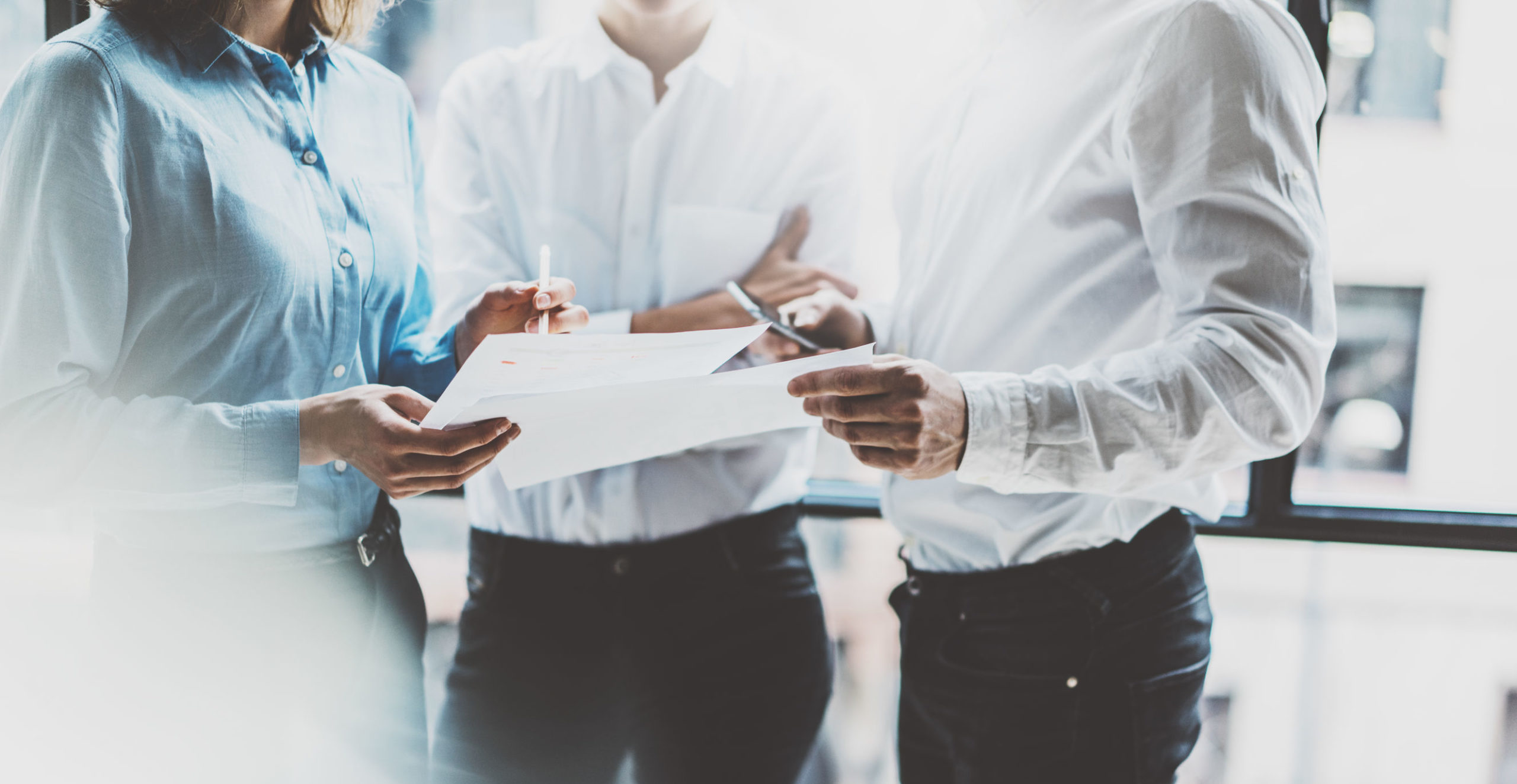 Business team meeting, work process. Photo professional crew working with new startup project. Project managers near window. Analyze business plans. Blurred background, film effect, bokeh. Horizontal